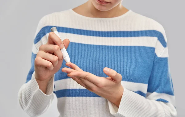 Teenage girl making blood test with lancing device — Stock Photo, Image