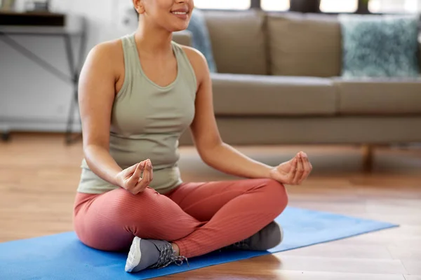 Donna meditando in posa loto yoga a casa — Foto Stock