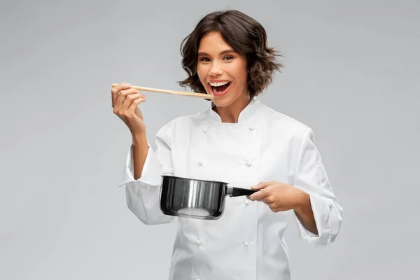 Chef feminino feliz com panela degustação de alimentos — Fotografia de Stock