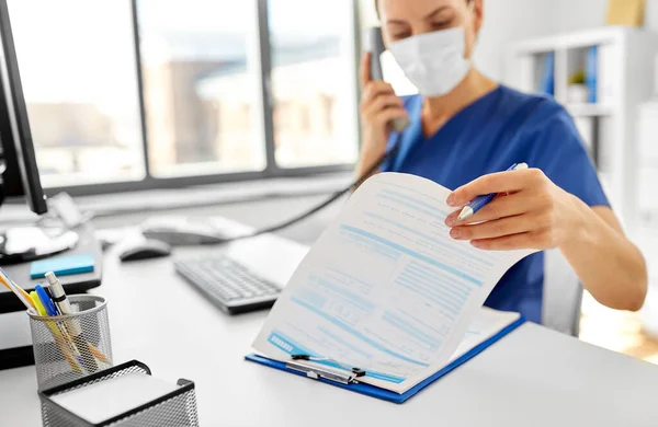 Doctor con computadora llamando por teléfono en el hospital — Foto de Stock