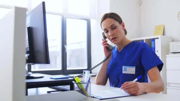 Médecin avec ordinateur appelant au téléphone à l'hôpital — Video