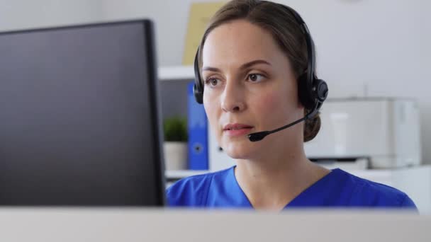 Médico con auriculares y ordenador en el hospital — Vídeos de Stock