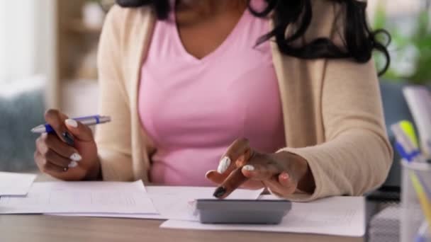 Femme avec calculatrice et papiers travaillant à la maison — Video