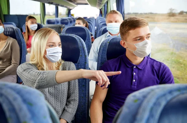 Pár cestujících v maskách v cestovním autobuse — Stock fotografie