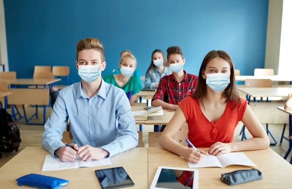 Skupina studentů v maskách na školní hodině — Stock fotografie