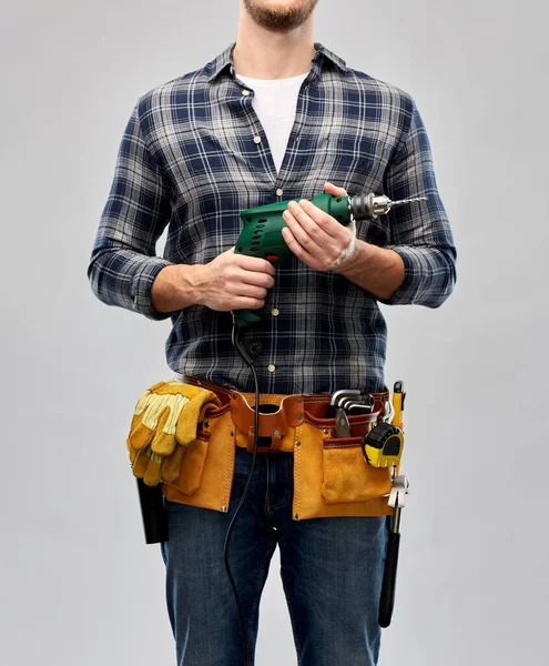 Мужчина-ремонтник или строитель с дрелью и рабочими инструментами — стоковое фото
