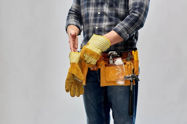 Budowniczy z narzędziami roboczymi zakładającymi rękawiczki — Zdjęcie stockowe