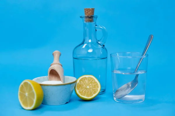 lemons, washing soda, bottle of vinegar and glass