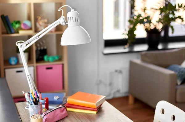 Room with lamp and school supplies on table — Stock Photo, Image