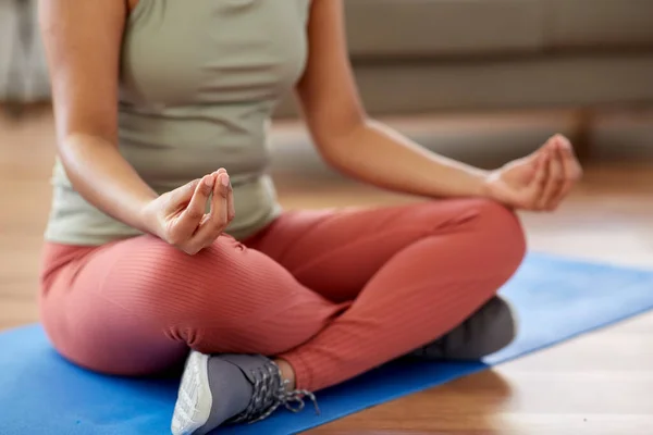 Donna meditando in posa loto yoga a casa — Foto Stock