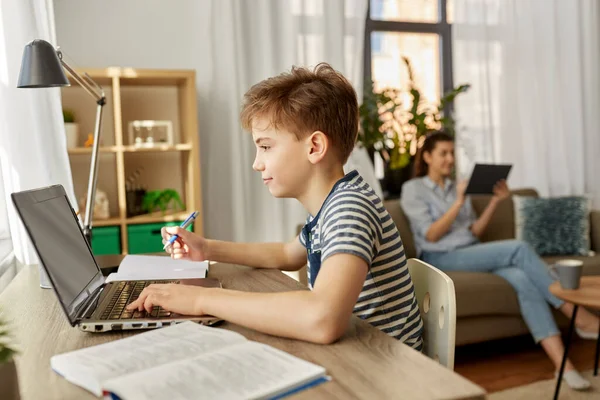 Student pojke med bärbar dator lärande hemma — Stockfoto