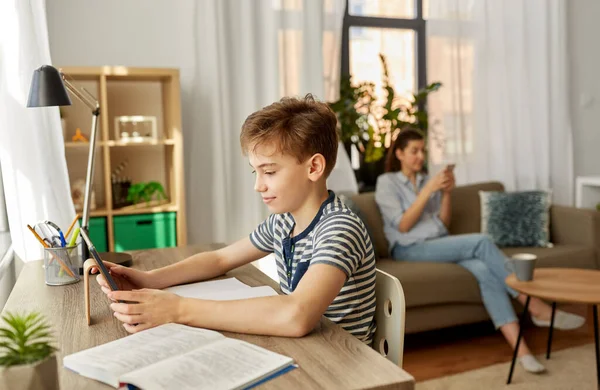 Student pojke med surfplatta datorinlärning hemma — Stockfoto