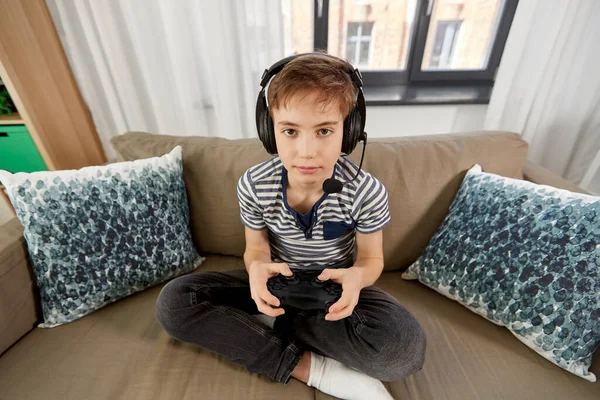 lazy teenager boy play computer games, sit in headphones, looking at screen  of laptop, free time at home Stock Photo