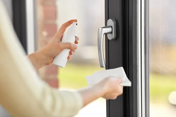 Kobieta czyszczenie uchwyt okna z tkanki dezynfekującej — Zdjęcie stockowe