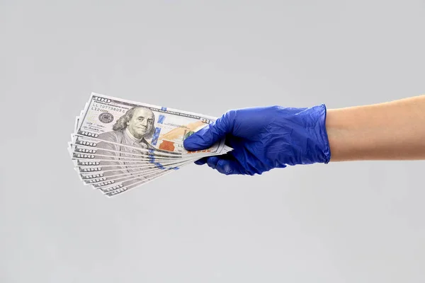 Zblízka ruky v lékařské rukavici s penězi — Stock fotografie