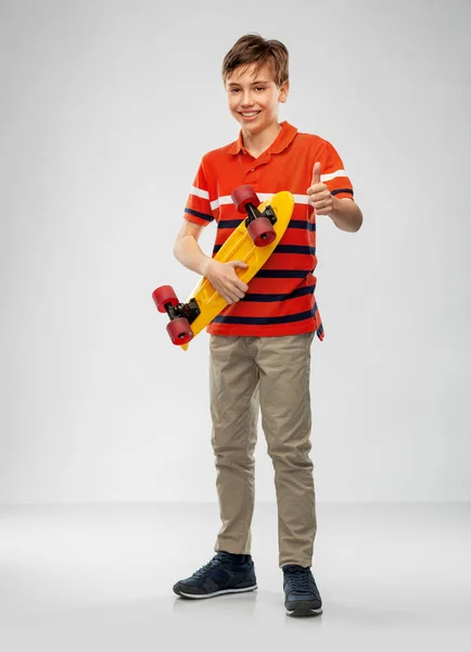 Smiling boy with short skateboard — Stock Photo, Image