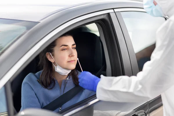 Az autóban koronavírus-vizsgálatot végző egészségügyi dolgozó — Stock Fotó
