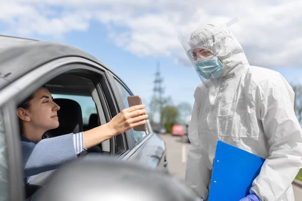 Mujer en coche mostrando fohe al trabajador de la salud —  Fotos de Stock