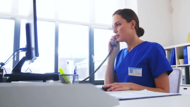 Doctor con computadora llamando por teléfono en el hospital — Vídeos de Stock