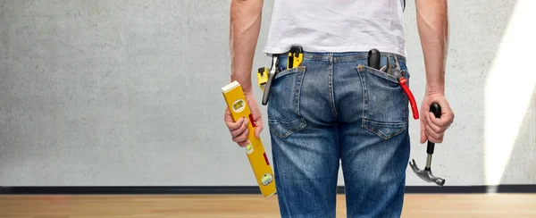 Hombre con nivel y herramientas de trabajo en bolsillos —  Fotos de Stock