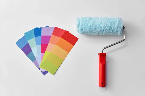Rodillo de pintura y paleta de colores sobre fondo blanco —  Fotos de Stock