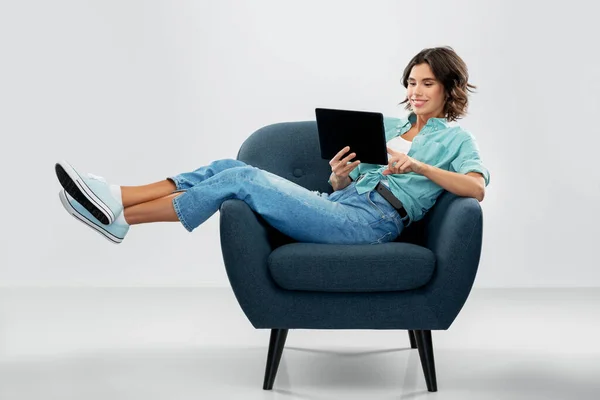 Ευτυχισμένη γυναίκα με tablet pc κάθεται στην πολυθρόνα — Φωτογραφία Αρχείου