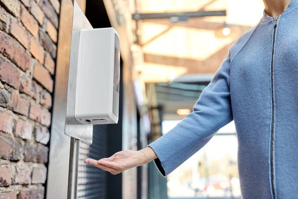 Close-up van de vrouw bij dispenser met de hand sanitizer — Stockfoto