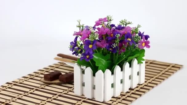 květiny s šálkem kávy na dřevěném ubrousku na pozadí točící se stůl