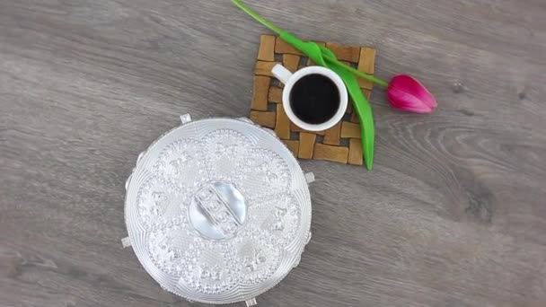 top view spinning video of coffee cup with metal casket with tulip
