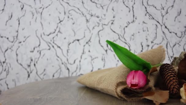 šálek kávy s houskou a tulipánem na hnědém plátně na točícím se dřevěném stole pozadí