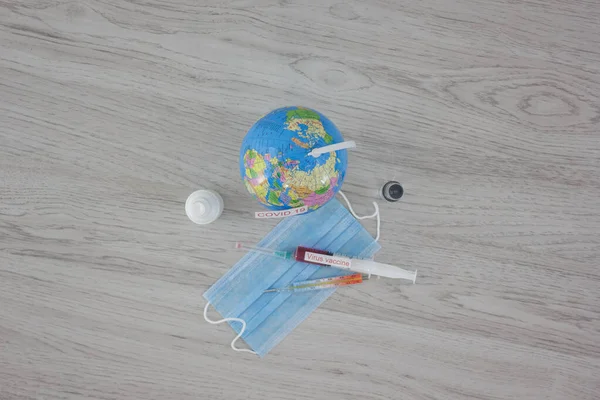 stethoscope with medical mask and vaccine with syringe protecting from coronavirus isolated on wooden table background
