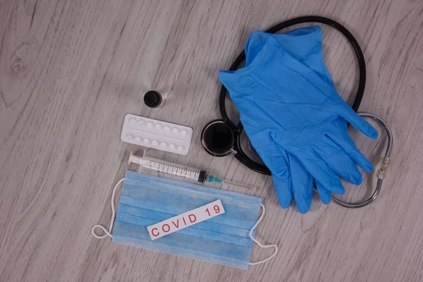 stethoscope with medical mask and vaccine with syringe protecting from coronavirus isolated on wooden table background