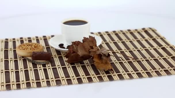 Šálek kávy s sladkosti na pozadí dřevěný stůl