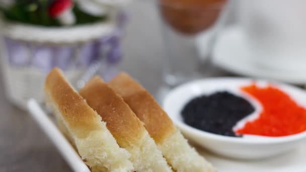 Morning breakfast with bread slices and red and black salty with boiled egg caviar on wooden table background — Stock Footage Morning Breakfast Bread Slices Red Black Salty Boiled Egg Caviar Video Clip