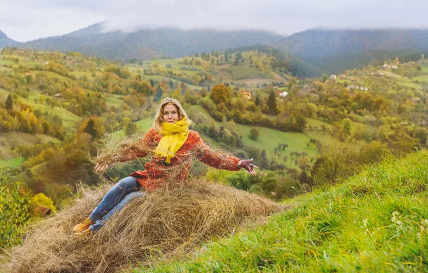 Heureux touriste assis dans le foin en automne — Photo