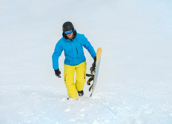 Uomo felice che tiene lo snowboard — Foto Stock