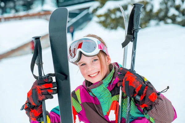 Счастливый ребенок с лыжами и лыжными палками — стоковое фото