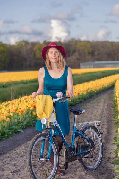Touristin mit ihrem Fahrrad in Tulpenfeldern Stockbild
