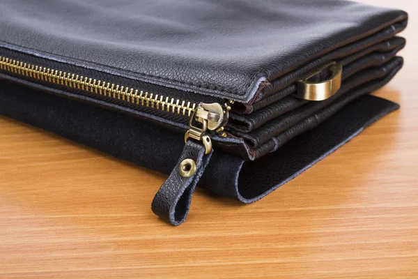 Pánská černá kožená taška na dřevěné pozadí — Stock fotografie