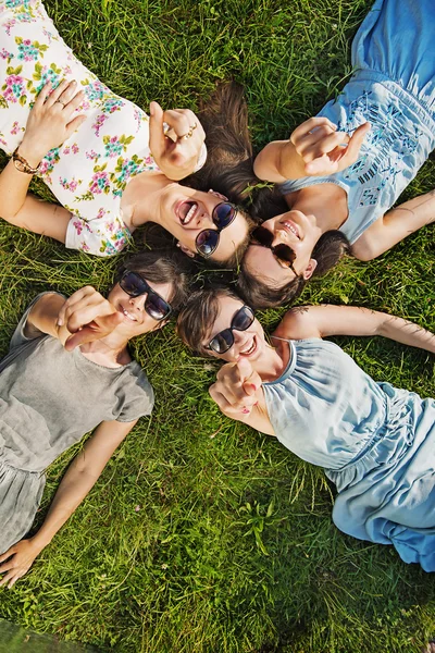 Quatro mulheres felizes vestindo óculos de sol na moda — Fotografia de Stock