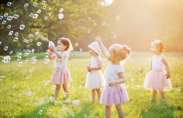Grupo de crianças bonitos soprando bolhas de sabão — Fotografia de Stock