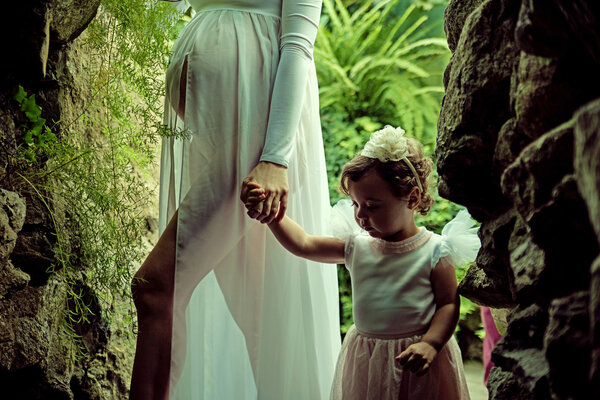 Pregnant mother walking with her little daughter