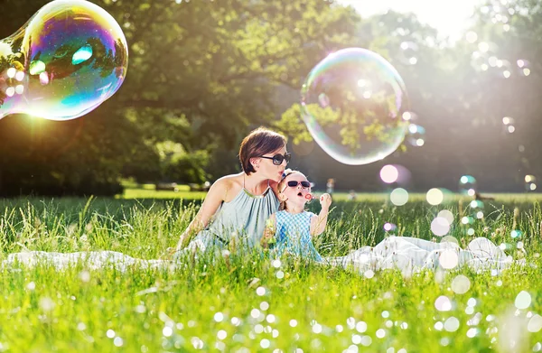 Madre e figlia famiglia tempo, soffiando sapone-bolle — Foto Stock