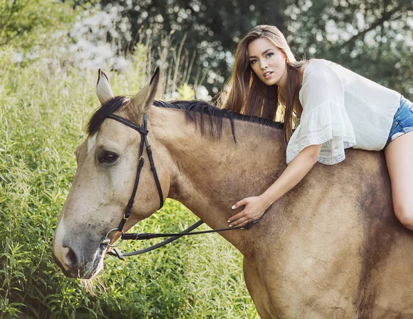 Retrato da mulher morena bonito montando um cavalo — Fotografia de Stock