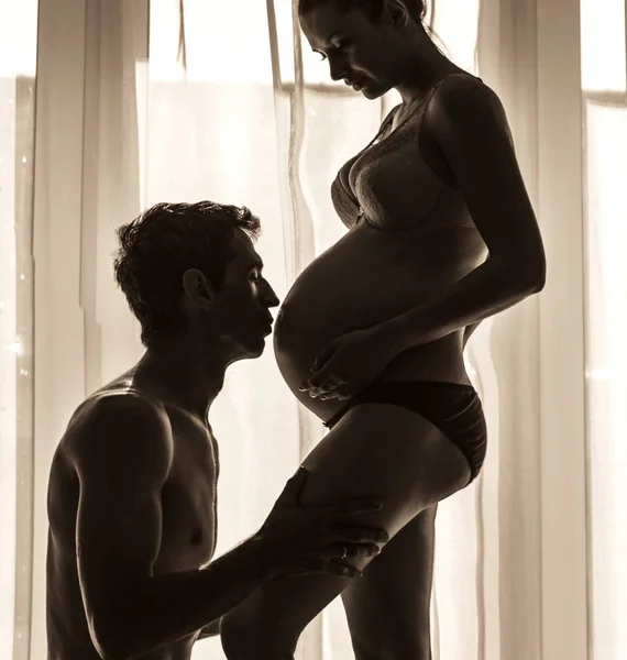 Proud dad kissing his wife's belly — Stock Photo, Image