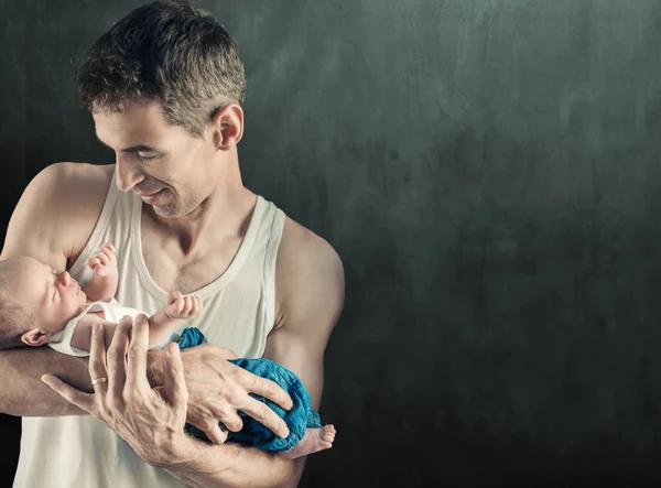Father holding newborn baby, over dark background — Stock Photo, Image