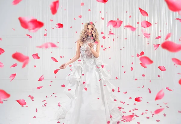 Bonita y elegante rubia bailando entre pétalos de rosa — Foto de Stock