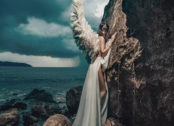 Schöner junger Engel klettert auf die Klippe — Stockfoto