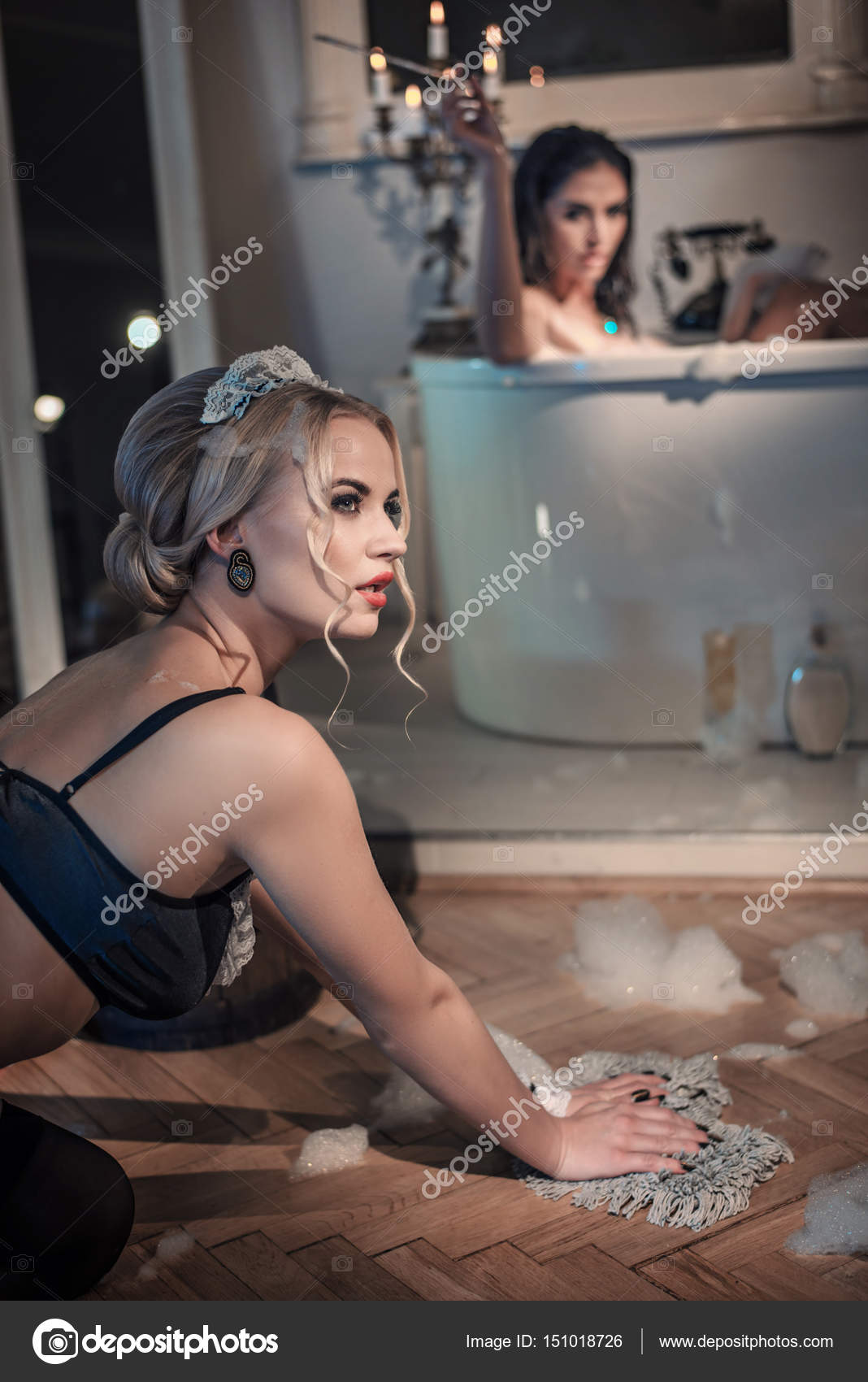 Atractiva camarera limpiar el piso en el cuarto de baño con estilo