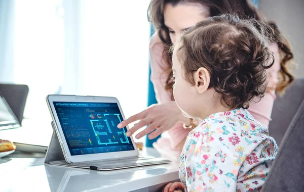 Mulher ensinando sua filha manipulação tablet — Fotografia de Stock